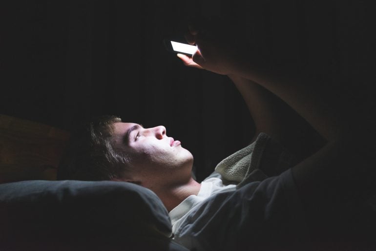 On phone in bed